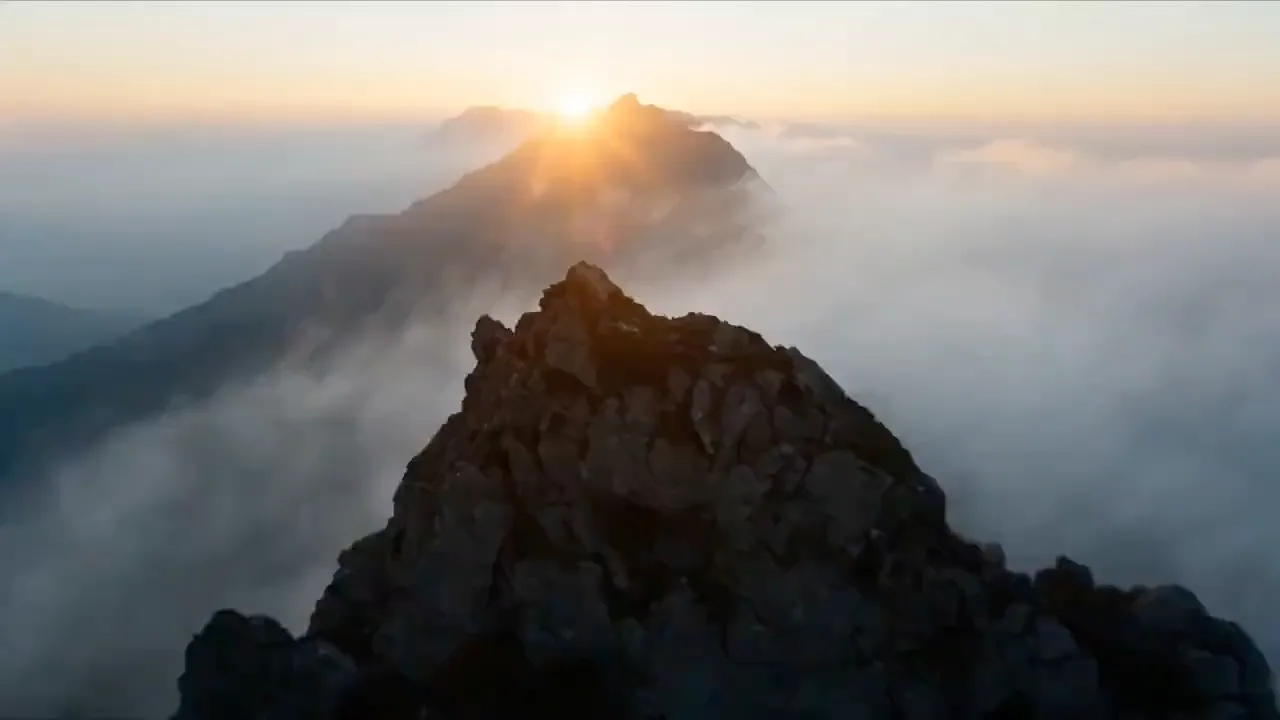 Sunrise over a mountain ridge above the clouds